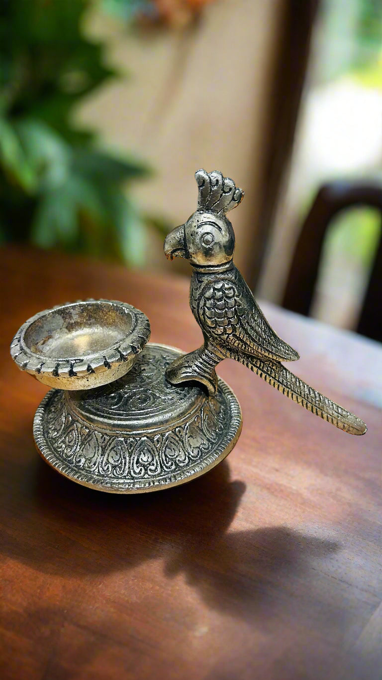 Decorative metal parrot figurine on a wooden surface