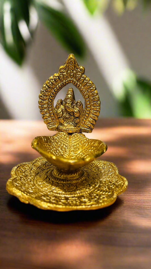 Gold-colored decorative item on a wooden surface with blurred green leaves in the background
